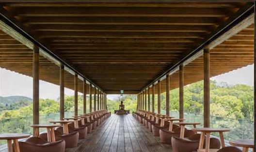 Galeria de madeira do Zenbo com poltronas voltadas para a floresta